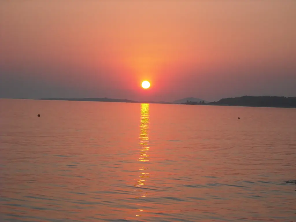 Ο ήλιος δύει πάνω από τον Τορωναίο κόλπο και αφήνει μια κόκκινη γραμμή στο νερό
